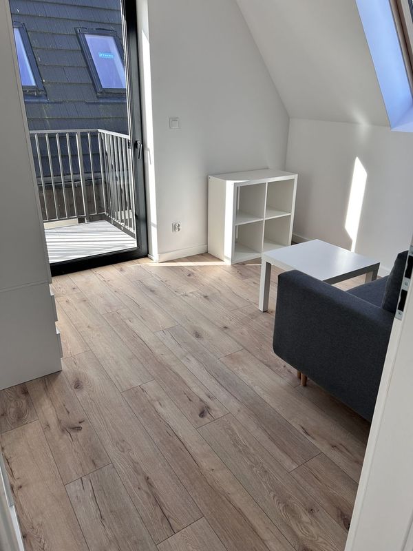 Jasny pokój na piętrze z fotelem i wyjściem na balkon